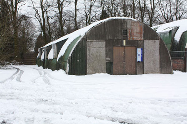 A half round ended nissen hut surrounded by snow